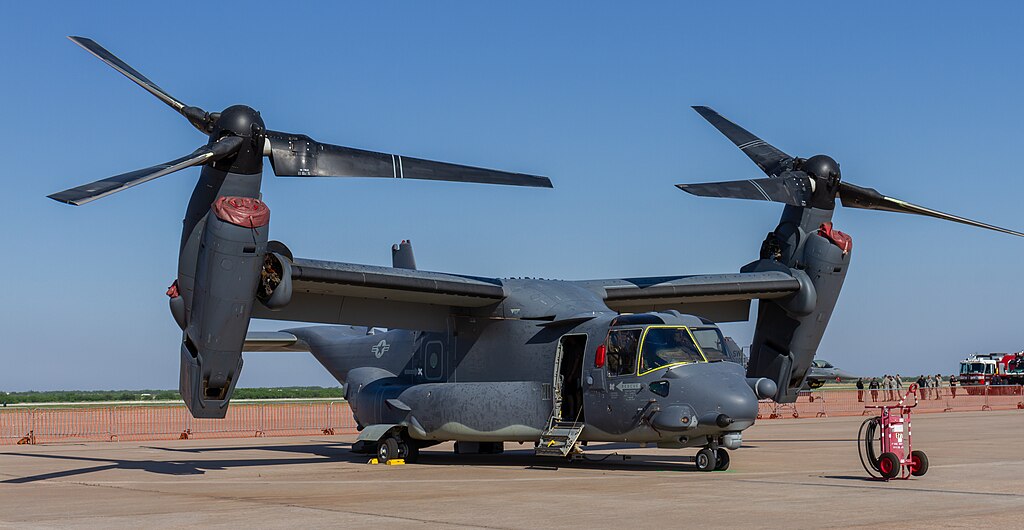 A gray V-22 Osprey tiltrotor aircraft is on the tarmac.