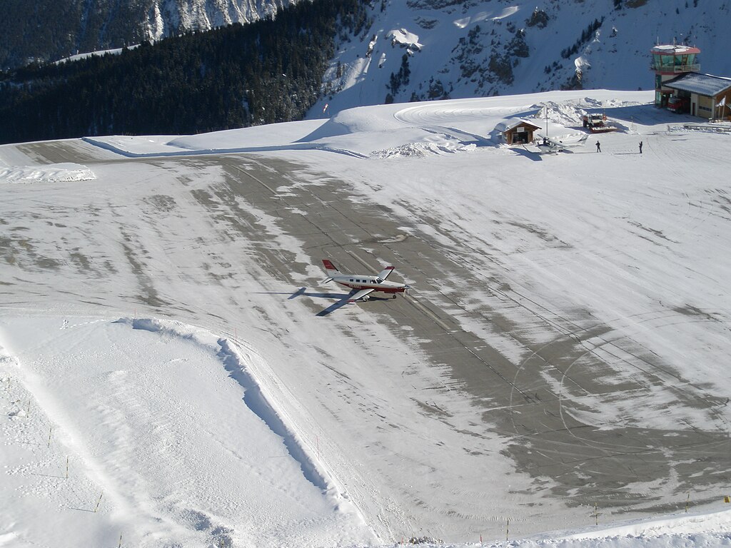 A piper PA46 on a snowy runway at a high-altitude airport.
